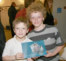 Young Curtis Dundas (right) whose instantly recognisable photo is featured on the front cover of the book is pictured with his brother Joel as he proudly shows his signed copy of the book.  Curtis and Joel are sons of the Rev Paul Dundas, Rector of Christ Church Parish, Lisburn.